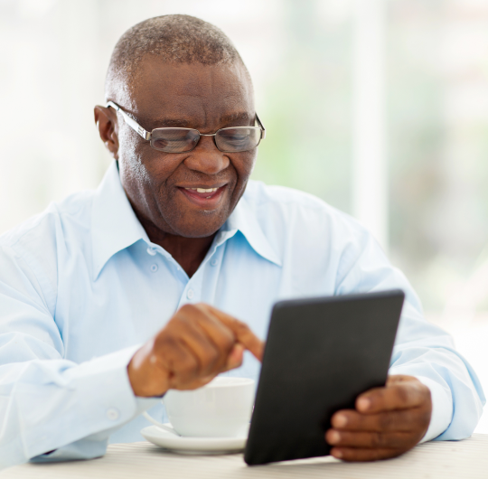 Hombre sonriendo y usando un computador portátil​​ 