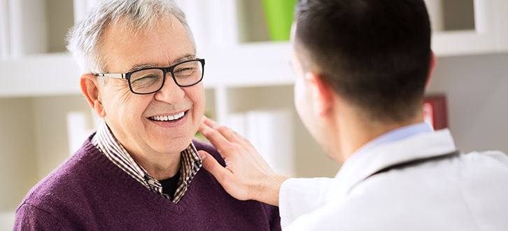 Hombre sonriente hablando con su médico​​ 