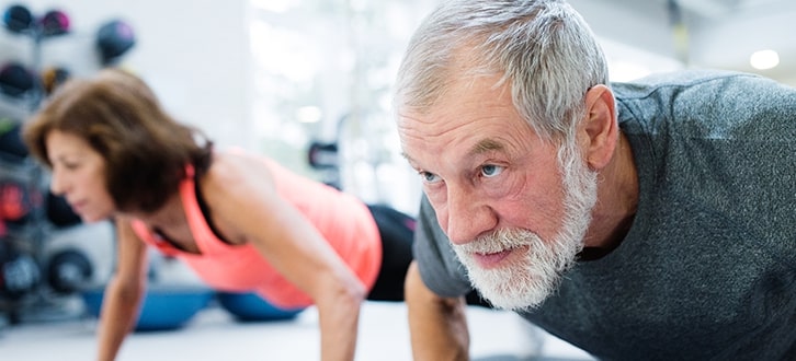 Una pareja haciendo flexiones de brazos en el gimnasio​​  