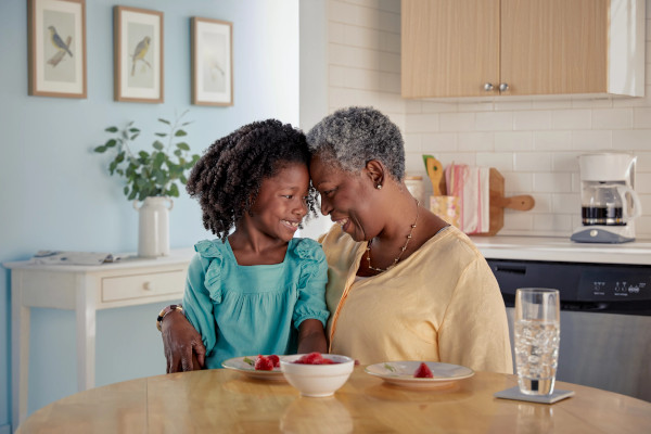 Abuela y nieta comiendo el desayuno​​ 
