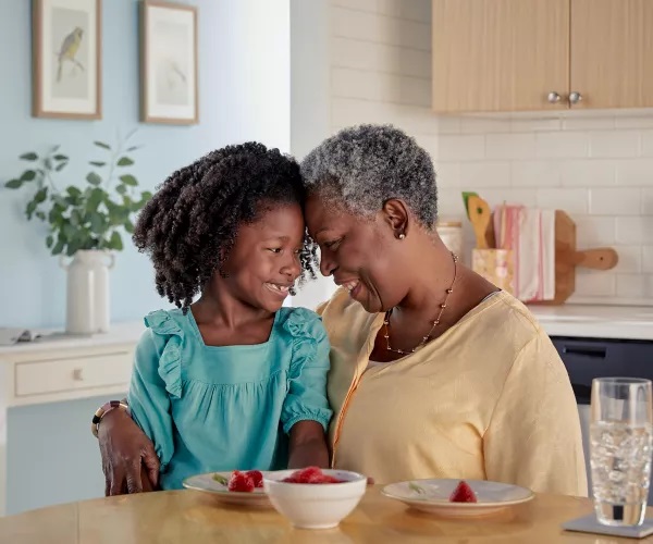 Abuela y nieta comiendo el desayuno​​ 