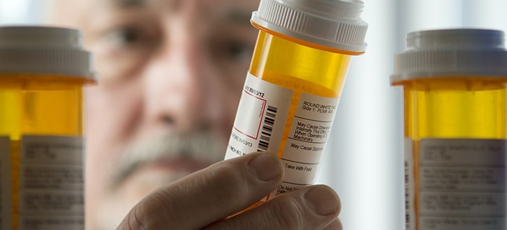 Hombre mirando medicamentos en un botiquín​​ 