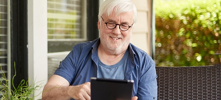 Hombre sonriente usando una tablet electrónica​​ 