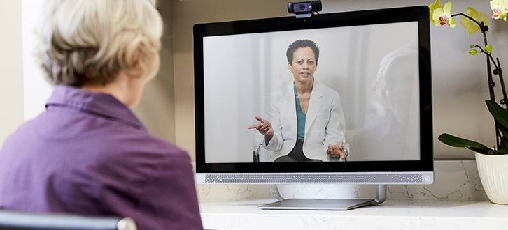 Mujer en una visita de telesalud con su médica​​ 