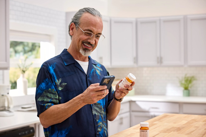 Un nuevo cliente de CenterWell Pharmacy usando su teléfono celular para comenzar a administrar sus medicamentos en línea.​​  